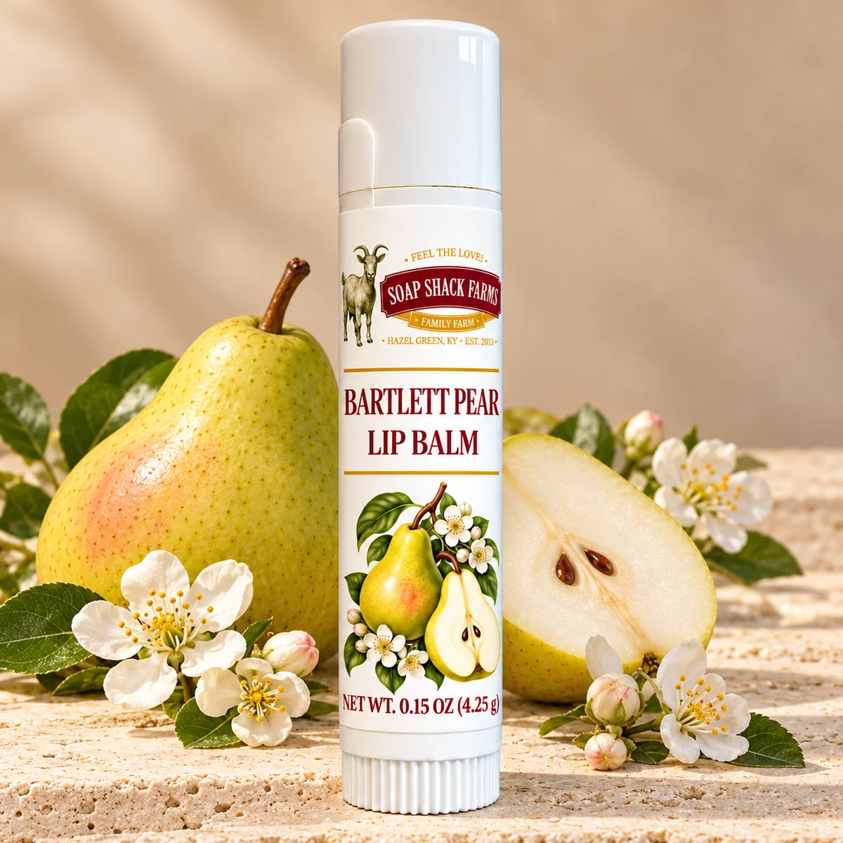 Soap Shack Farms Bartlett Pear Lip Balm in a white 0.15 oz tube on a stone surface with flavor-inspired botanicals in a warm studio setting.