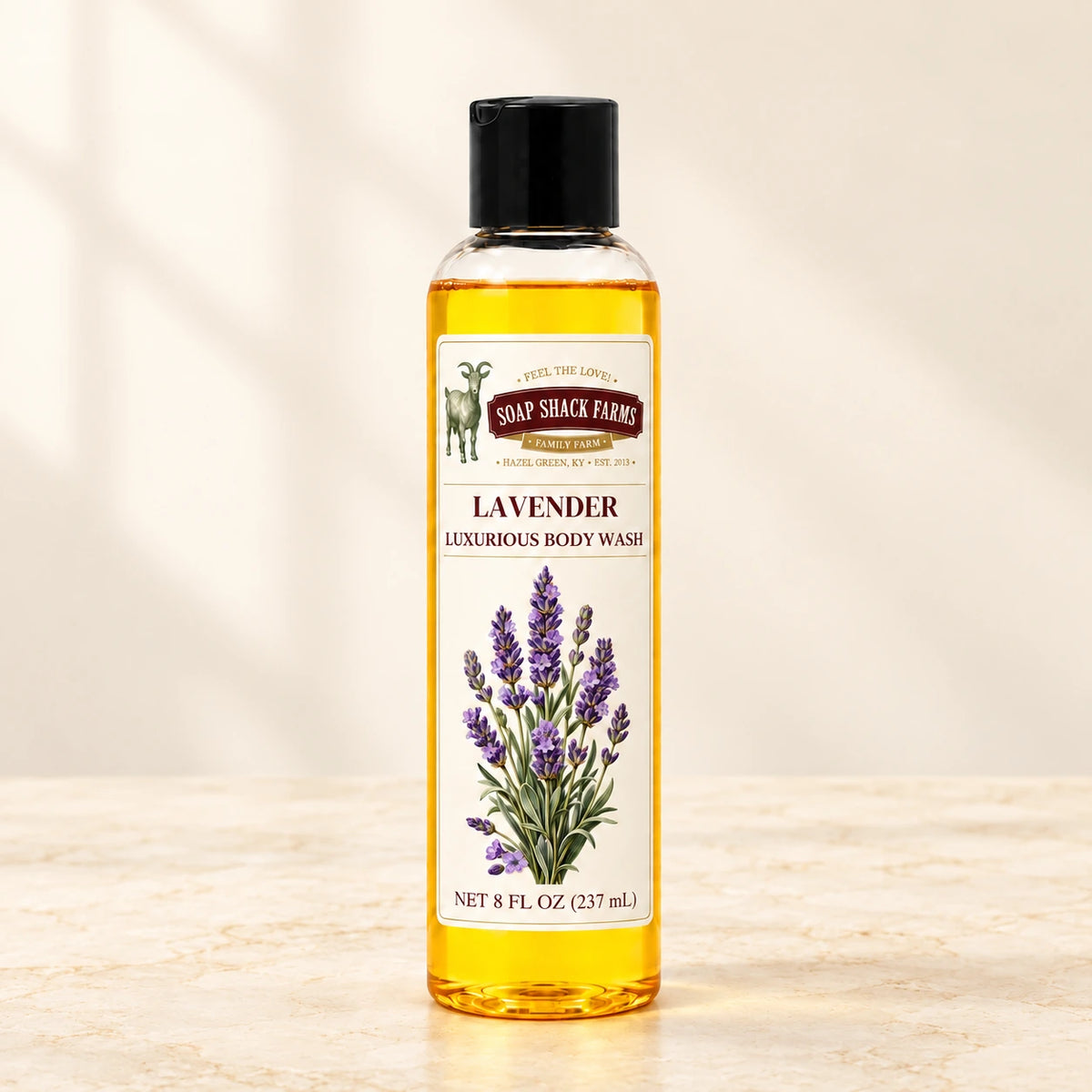 Lavender luxurious body wash in a slender clear bottle on a warm cream studio background.