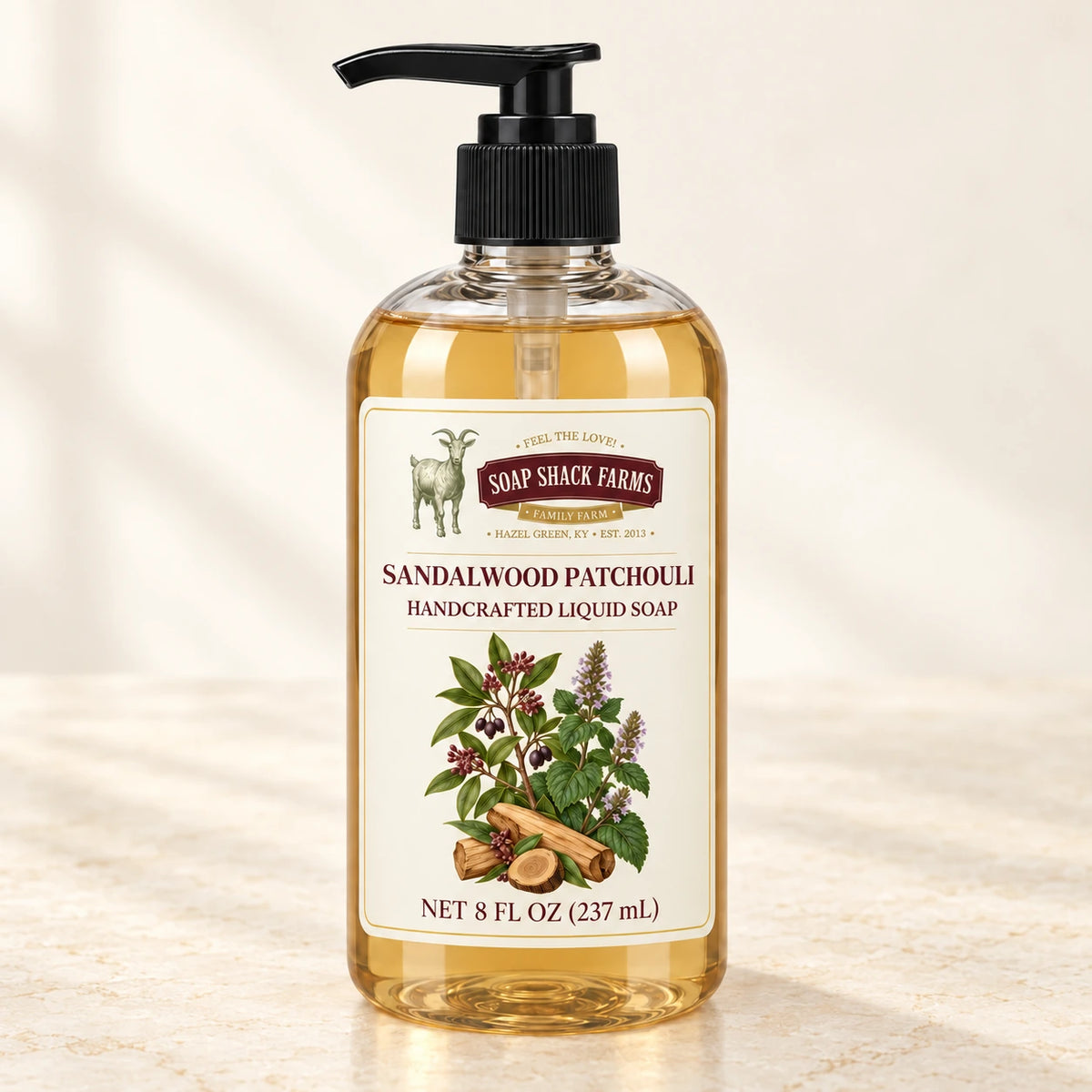 Sandalwood Patchouli handcrafted liquid soap in a clear pump bottle on a warm cream studio background.