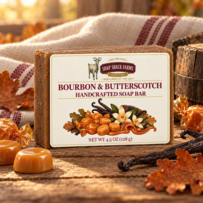 Bourbon and Butterscotch olive oil soap bar on rustic wood with candies, vanilla, oak leaves, barrel wood, and farmhouse linen.