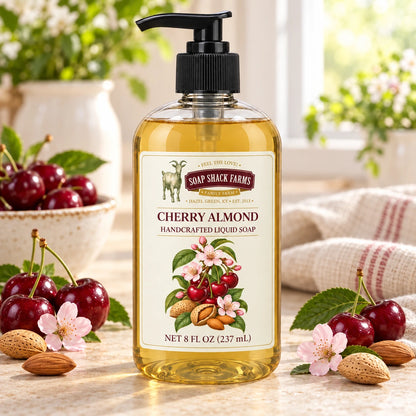 Cherry Almond handcrafted liquid soap with ripe cherries, almonds, pink blossoms, and farmhouse linen in a sunlit setting.