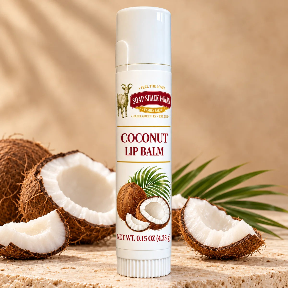 Soap Shack Farms Coconut Lip Balm in a white 0.15 oz tube on a stone surface with flavor-inspired botanicals in a warm studio setting.