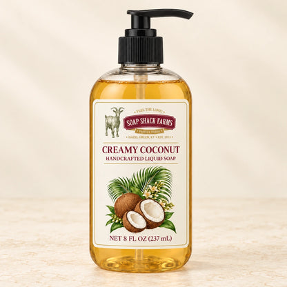 Creamy Coconut handcrafted liquid soap in a clear pump bottle on a warm cream studio background.