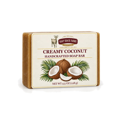 Creamy Coconut handcrafted olive oil soap bar with coconut and palm botanical label on a white background.