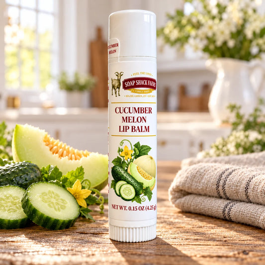 Soap Shack Farms Cucumber Melon Lip Balm in a white 0.15 oz tube on a rustic wooden table with linen in a sunlit farmhouse setting.