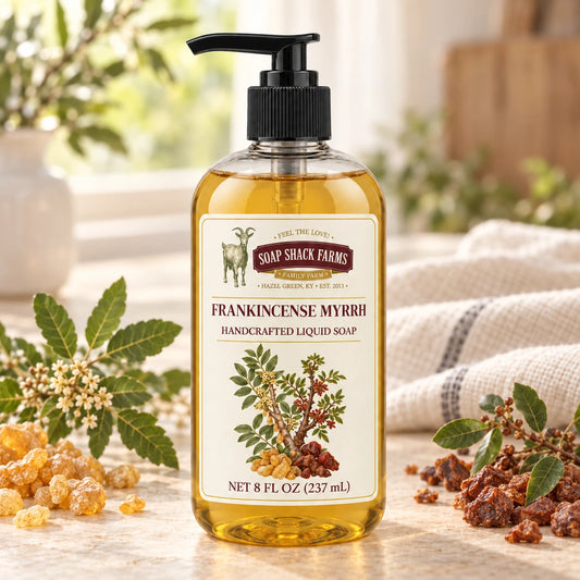 Frankincense and Myrrh handcrafted liquid soap with golden frankincense resin, reddish-brown myrrh, leafy branches, and farmhouse linen.
