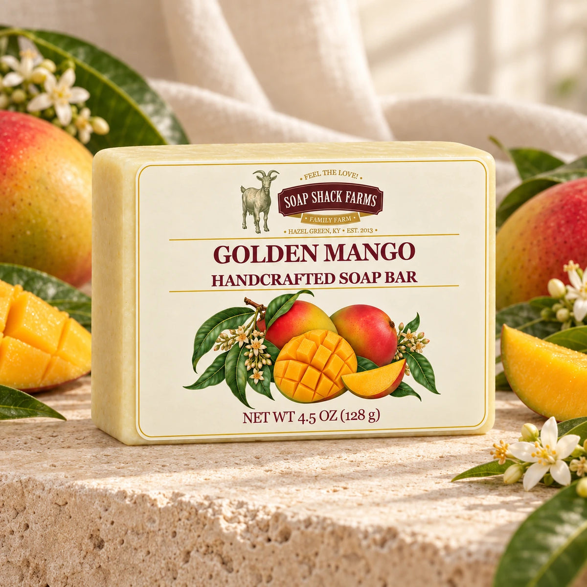 Golden Mango olive oil soap bar on warm cream stone with ripe mangoes, leaves, and blossoms.