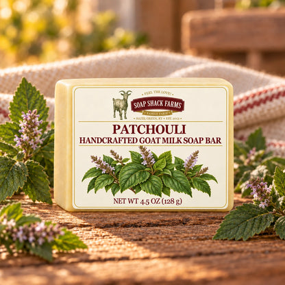 Soap Shack Farms Patchouli goat milk soap with flowering patchouli plants on a sunlit rustic wood table.