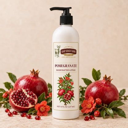 Soap Shack Farms Pomegranate Handcrafted Body Lotion surrounded by ripe pomegranates, ruby seeds, blossoms, and green leaves
