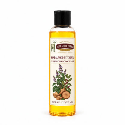 Sandalwood Patchouli luxurious body wash in a slender clear 8 oz bottle with a black disc-top cap on a white background.
