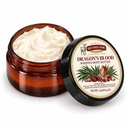 Soap Shack Farms Dragons Blood Whipped Body Butter in an open amber jar showing ivory whipped texture beside its labeled black lid.
