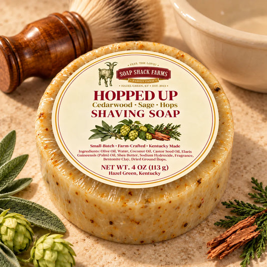 Soap Shack Farms Hopped Up shaving soap on pale stone with a shaving brush, bowl, and cedar, sage and hops accents.