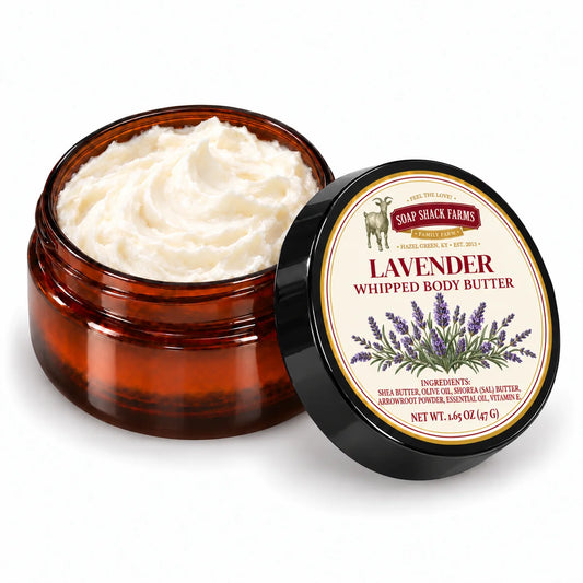 Soap Shack Farms Lavender Whipped Body Butter in an open amber jar showing ivory whipped texture beside its labeled black lid.