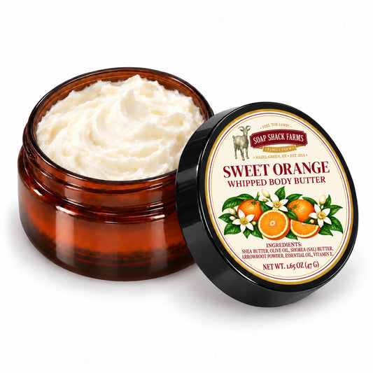 Soap Shack Farms Sweet Orange Whipped Body Butter in an open amber jar showing ivory whipped texture beside its labeled black lid.