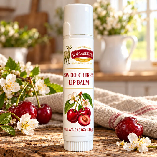 Soap Shack Farms Sweet Cherry Lip Balm in a white 0.15 oz tube on a rustic wooden table with linen in a sunlit farmhouse setting.