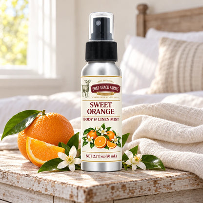 Soap Shack Farms Sweet Orange body and linen mist on a farmhouse bedside table with natural botanicals and linen.