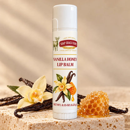 Soap Shack Farms Cucumber Melon Lip Balm in a white 0.15 oz tube on a stone surface with flavor-inspired botanicals in a warm studio setting.