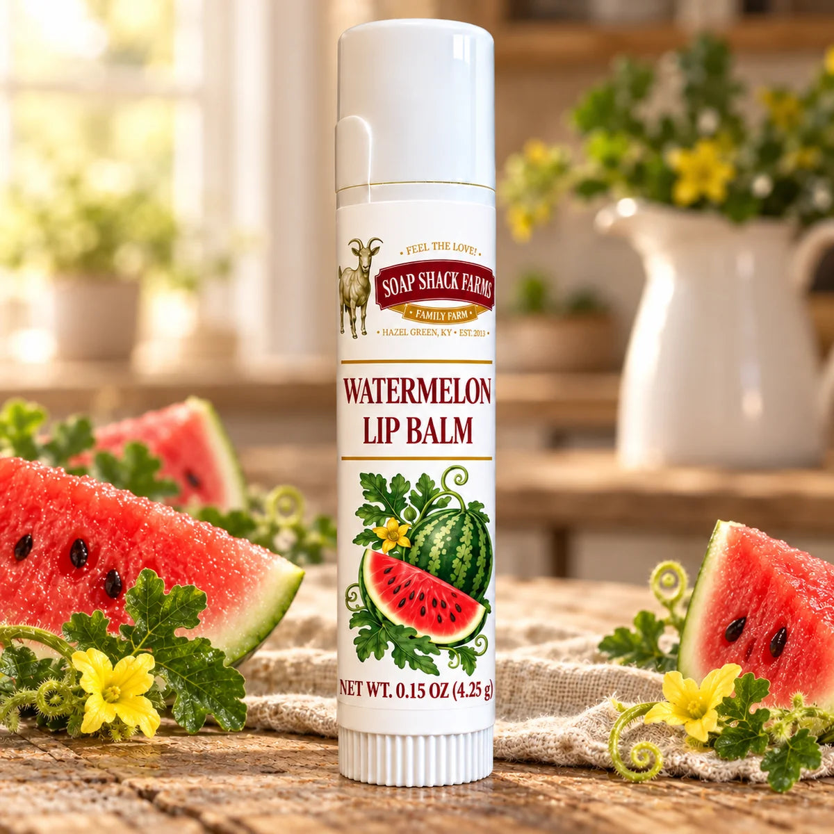 Soap Shack Farms Watermelon Lip Balm in a white 0.15 oz tube on a rustic wooden table with linen in a sunlit farmhouse setting.